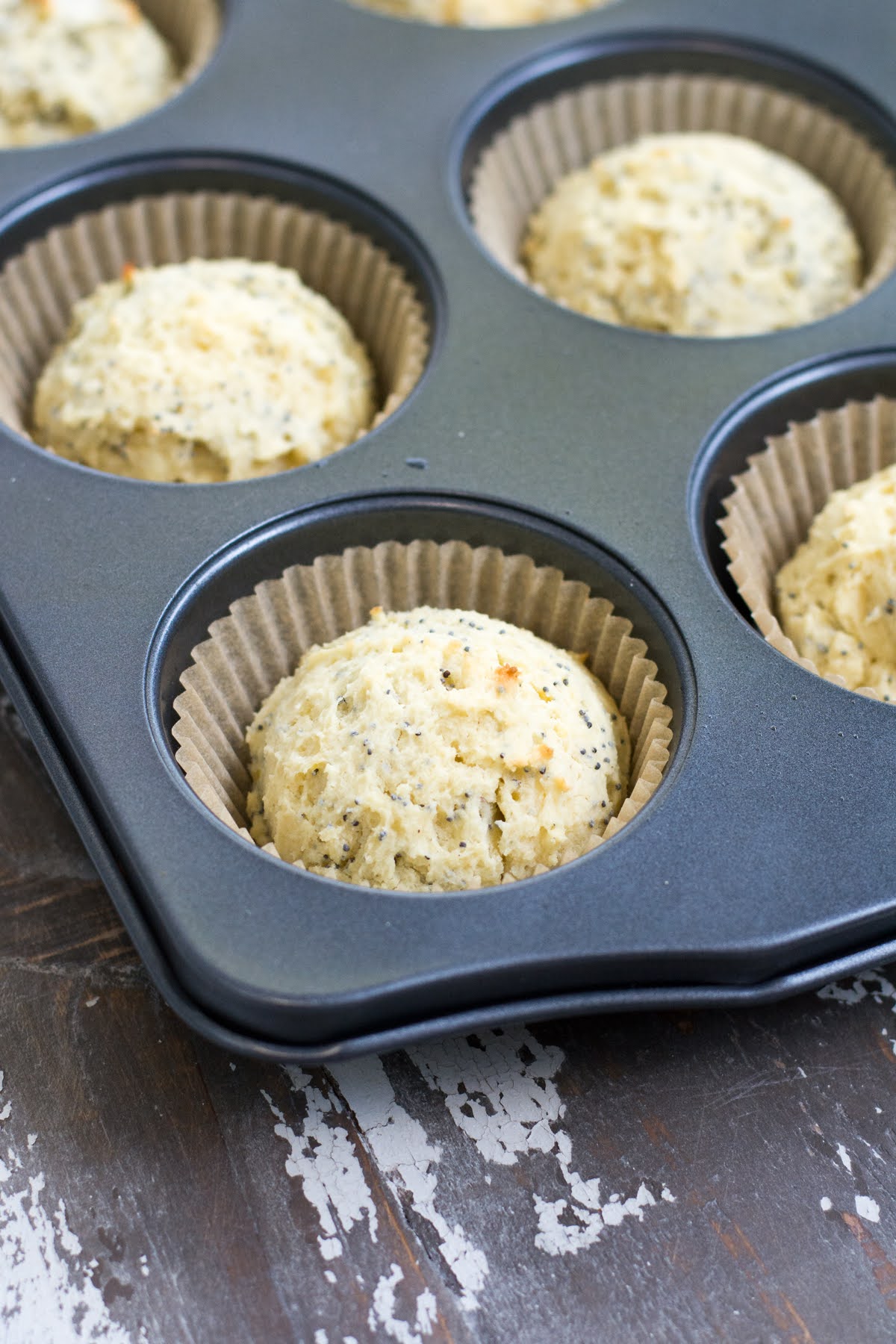 These are the perfect Gluten Free Lemon Poppyseed Muffins. Real lemon and crunchy poppy seeds in a tender, sweet muffin. Easy to make! Close-up shot of small muffins baked in a muffin tin.