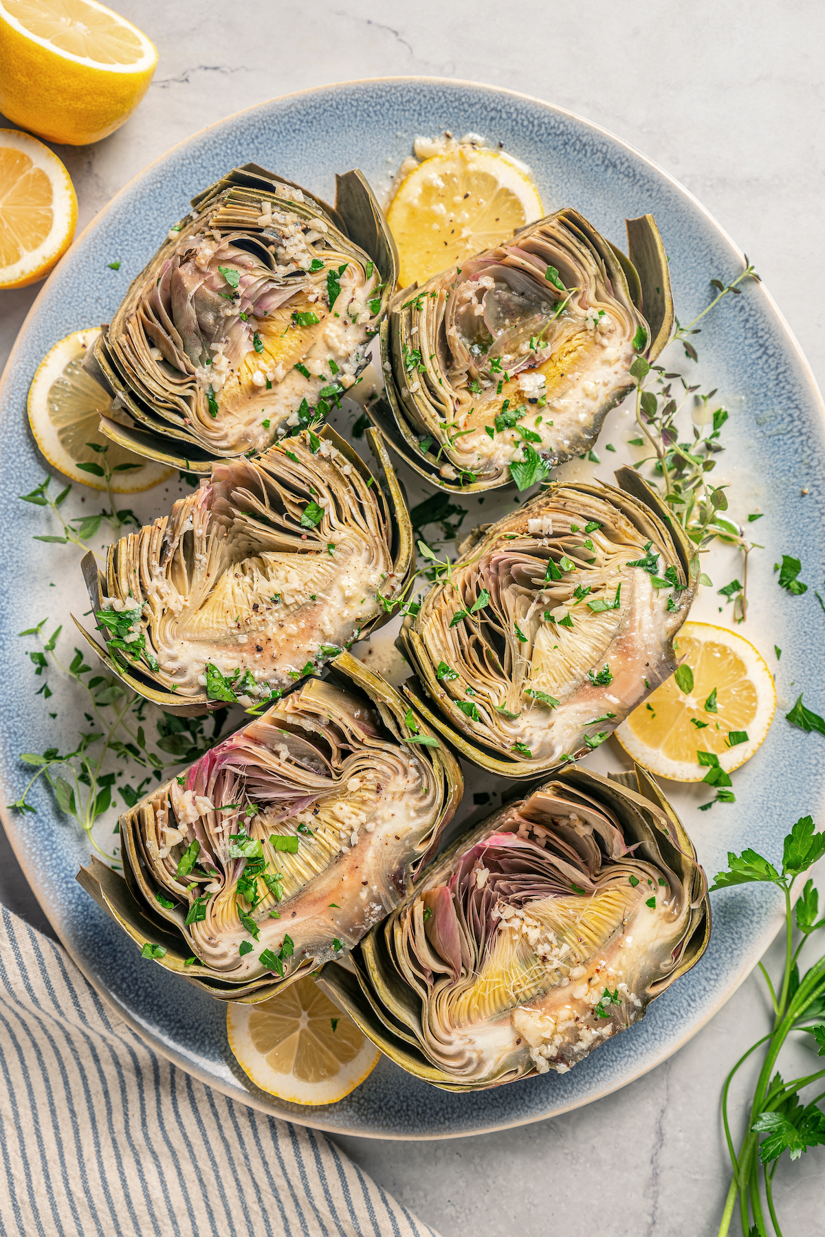 This tender Instant Pot artichokes recipe with hints of tangy lemon, garlic, and fresh herbs will be your go-to holiday side dish.
