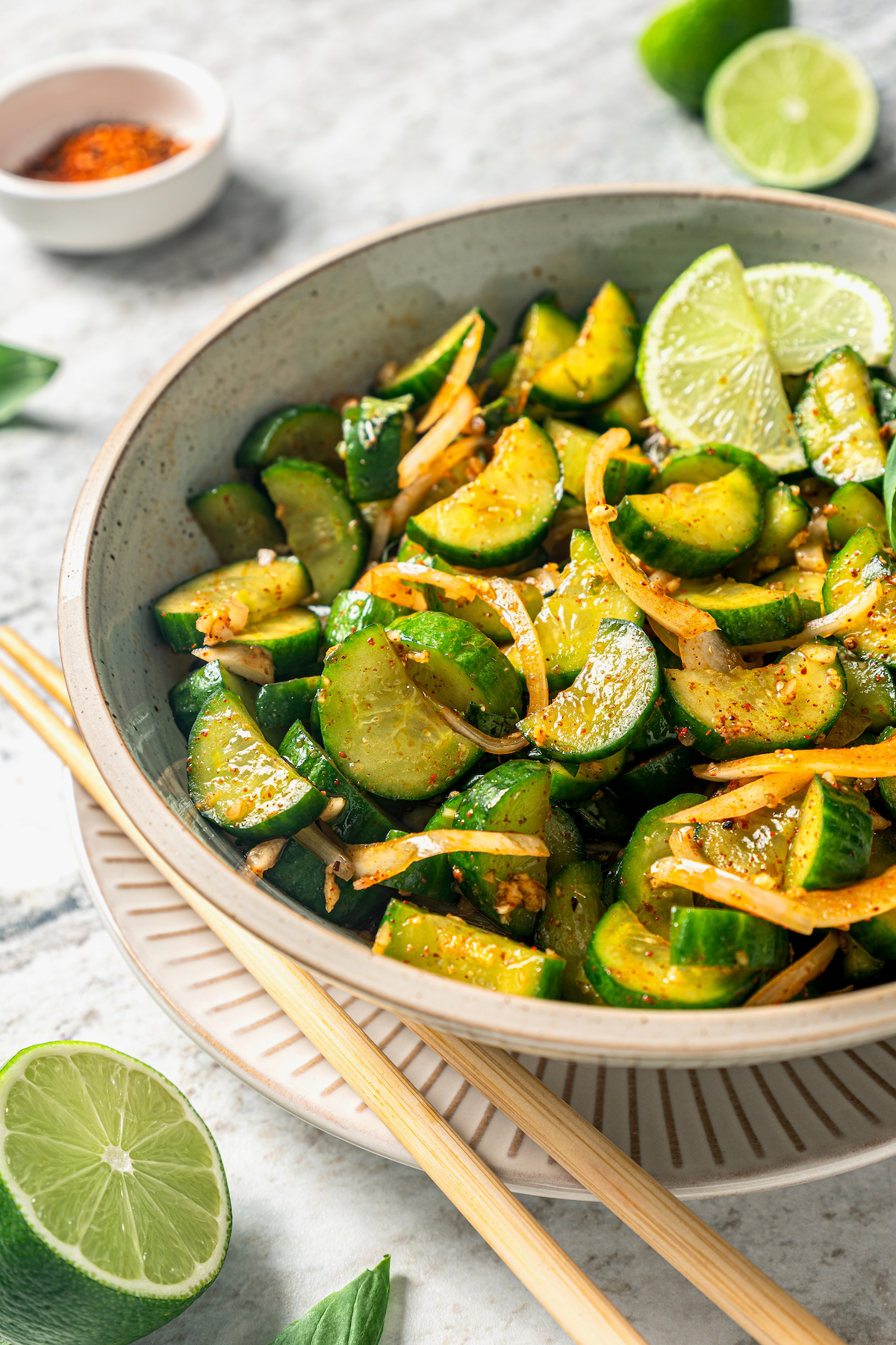 This easy cucumber kimchi recipe with gochugaru pepper and tangy fish sauce is the fastest way to put Korean kimchi on the table for dinner. Cucumber kimchi in a bowl with chopsticks on the side.